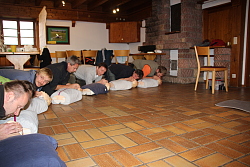 Das Bild zeigt die Teilnehmer der Fortbildung "Outdoor-Erste-Hilfe" in einem Raum auf dem Boden kauernd. Vor ihnen liegen Erste-Hilfe-Übungspuppen an denen sie Mund-zu-Mund-Beatmung üben.